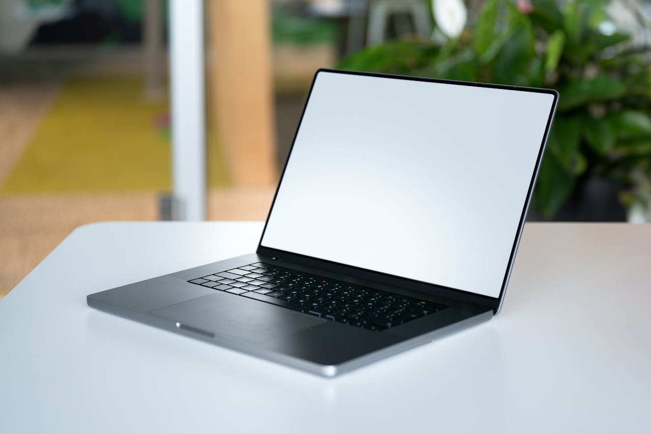 The Art of Drawing Readers In: Your attractive post title goes here A modern laptop with blank screen placed on a white desk in an office environment, ideal for business presentations.